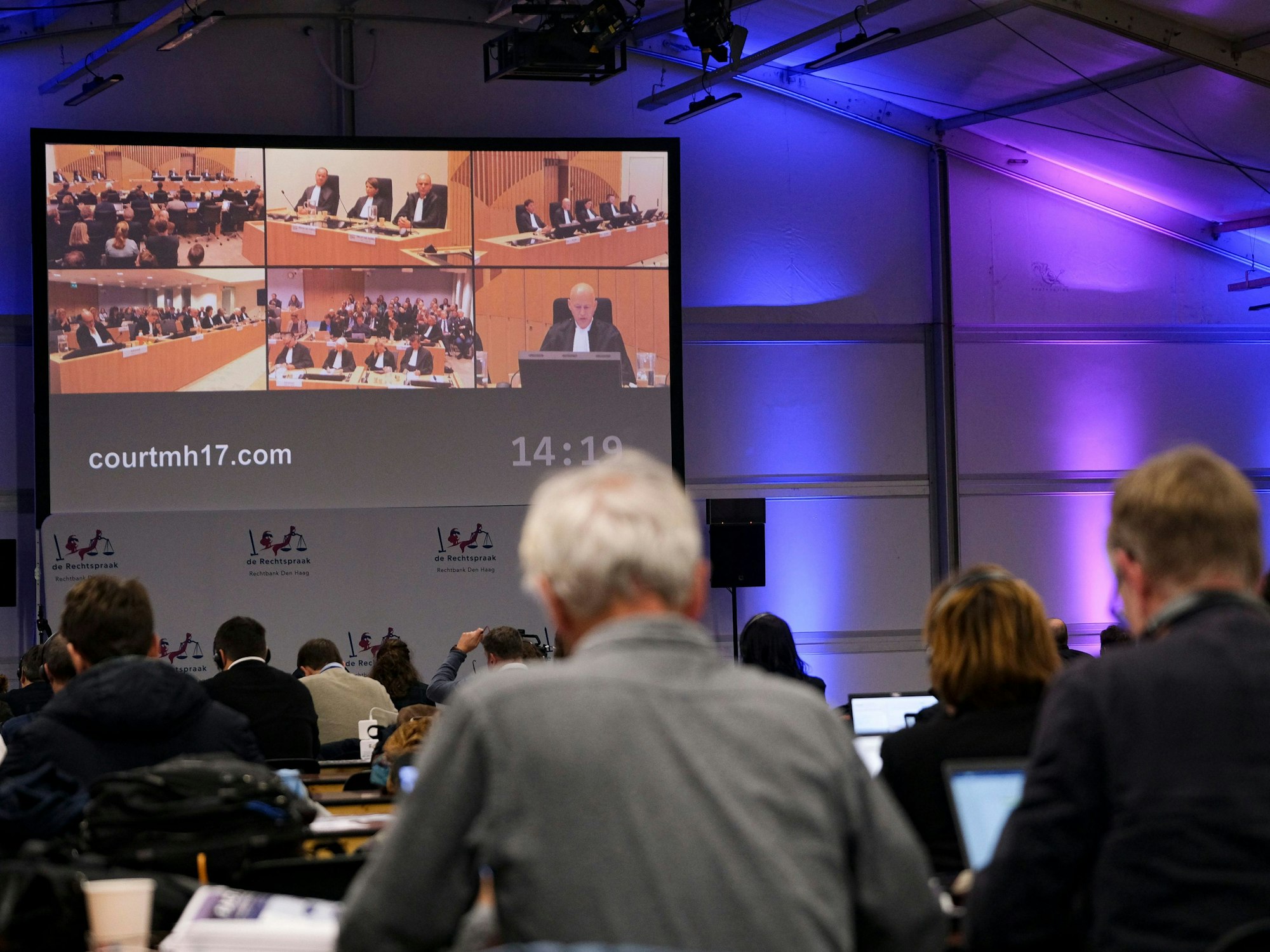 Journalisten verfolgen auf einem großen Bildschirm die Urteilsverkündung im Prozess um den Abschuss von Flug MH17.