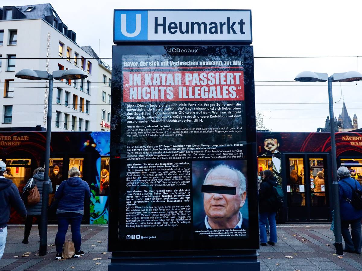 Plakat mit Foto und Aussagen von Uli Hoeneß am Neumarkt in Köln. Viele Menschen stehen drum herum.