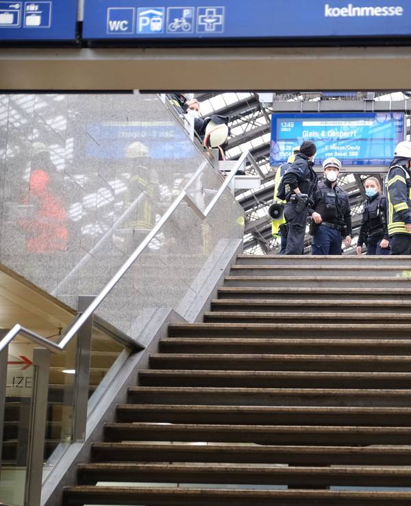 Rettungskräfte stehen am Kölner Hauptbahnhof und kümmern sich um einen Verletzten.