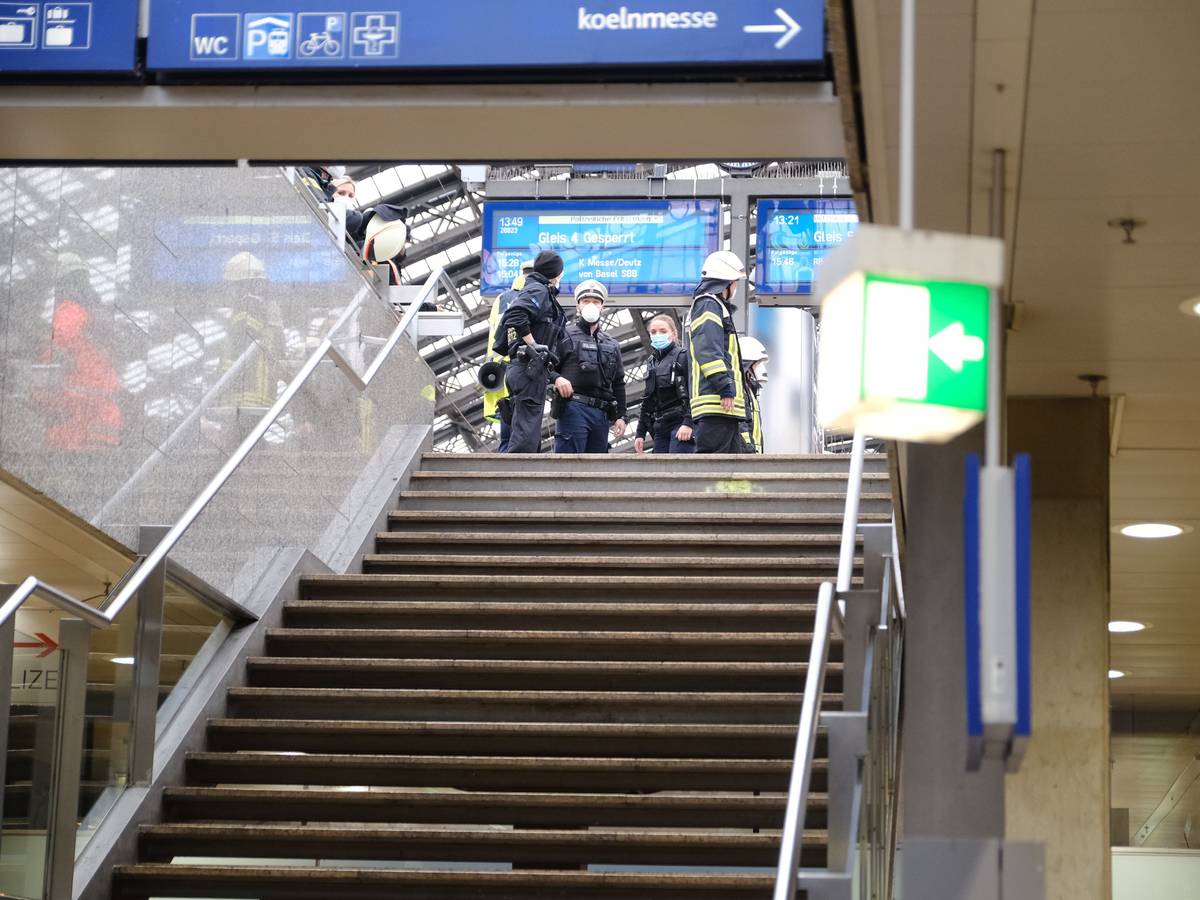 Rettungskräfte stehen am Kölner Hauptbahnhof und kümmern sich um einen Verletzten.