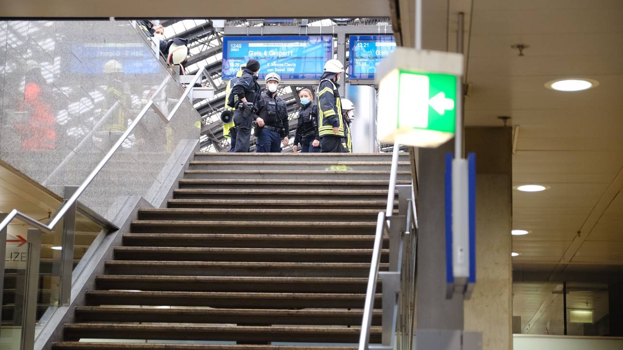 Rettungskräfte stehen am Kölner Hauptbahnhof und kümmern sich um einen Verletzten.