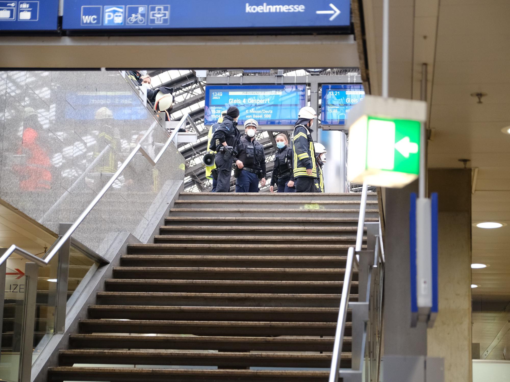 Rettungskräfte stehen am Kölner Hauptbahnhof und kümmern sich um einen Verletzten.