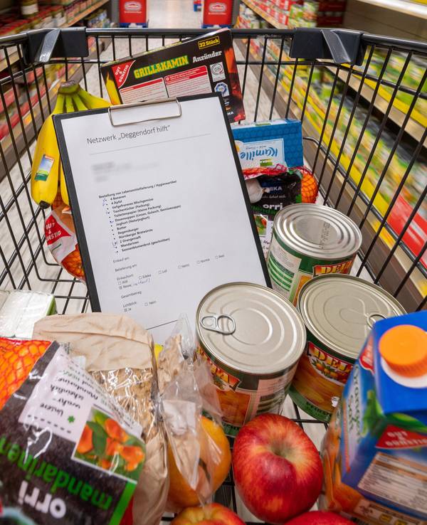Nach einem Preisvergleich mit anderen Supermärkten schimpft eine Kundin gegen Aldi. Unser Foto zeigt einen Einkaufswagen mit einer Preisliste und verschiedenen Produkten.