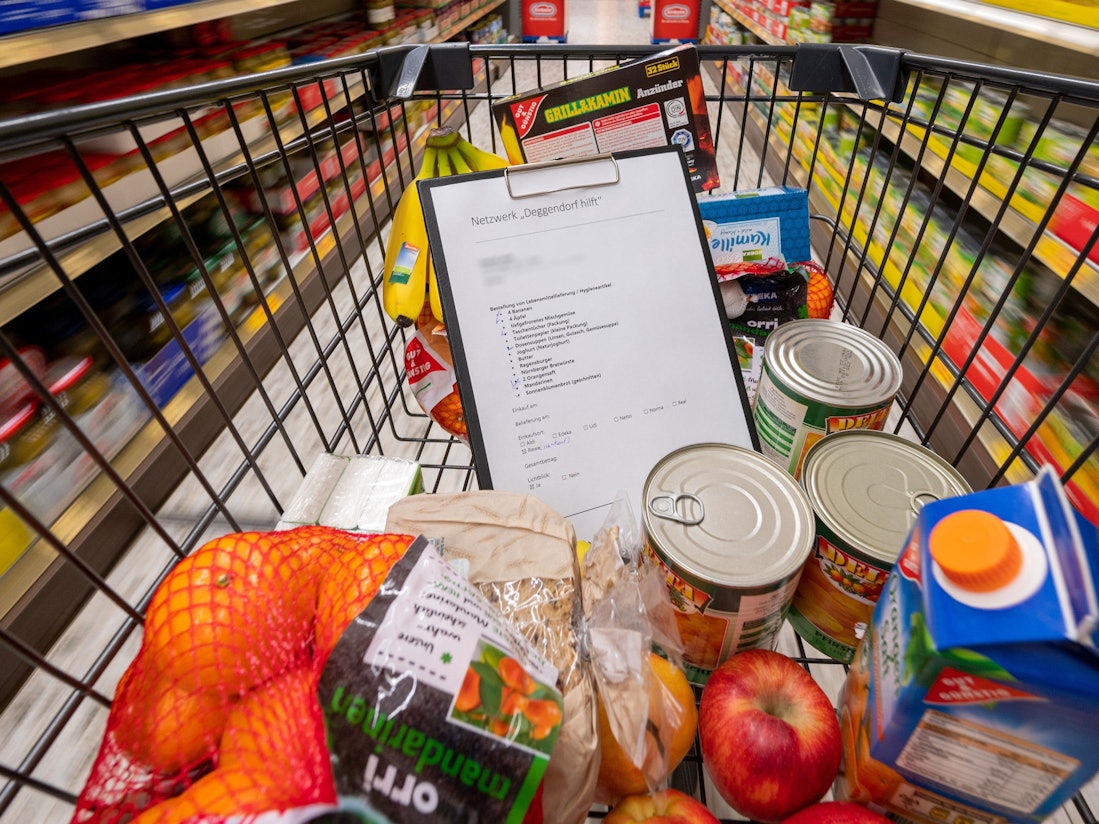 Nach einem Preisvergleich mit anderen Supermärkten schimpft eine Kundin gegen Aldi. Unser Foto zeigt einen Einkaufswagen mit einer Preisliste und verschiedenen Produkten.
