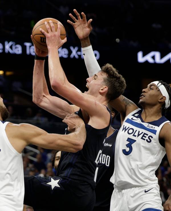 Franz Wagner (22) von den Orlando Magic wirft zwischen Minnesota Timberwolves-Center Rudy Gobert (27) und Forward Jaden McDaniels (3).