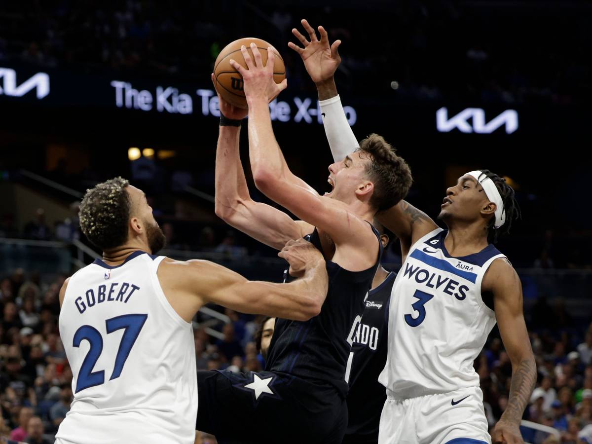 Franz Wagner (22) von den Orlando Magic wirft zwischen Minnesota Timberwolves-Center Rudy Gobert (27) und Forward Jaden McDaniels (3).