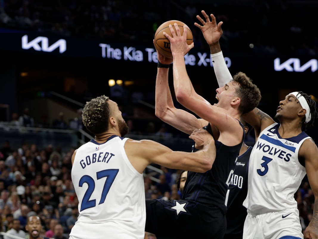 Franz Wagner (22) von den Orlando Magic wirft zwischen Minnesota Timberwolves-Center Rudy Gobert (27) und Forward Jaden McDaniels (3).