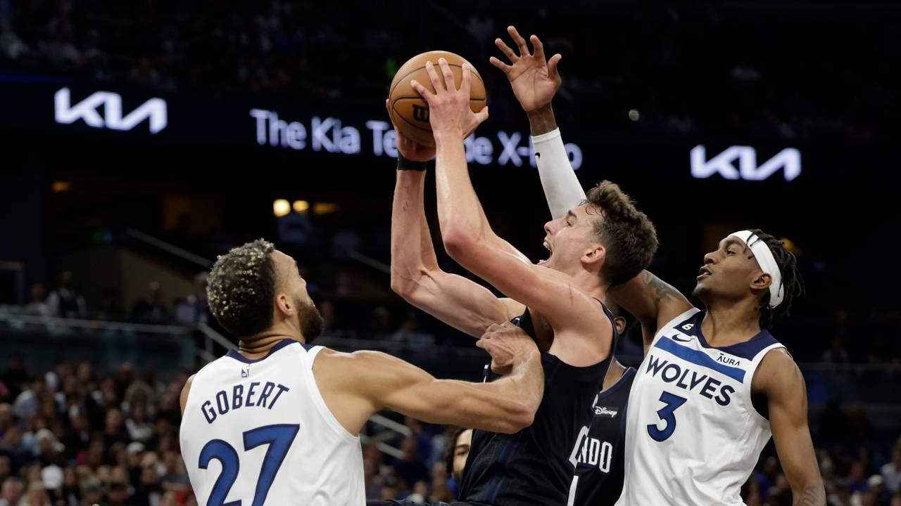 Franz Wagner (22) von den Orlando Magic wirft zwischen Minnesota Timberwolves-Center Rudy Gobert (27) und Forward Jaden McDaniels (3).