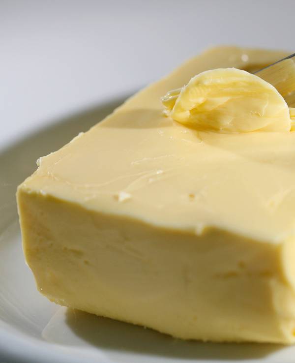 Mit einem Messer wird Butter abgestrichen.