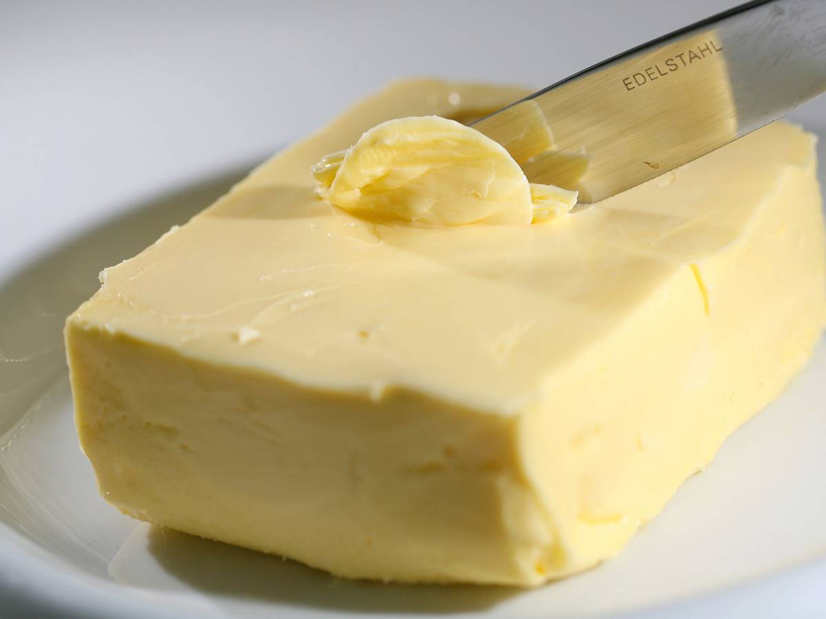 Mit einem Messer wird Butter abgestrichen.