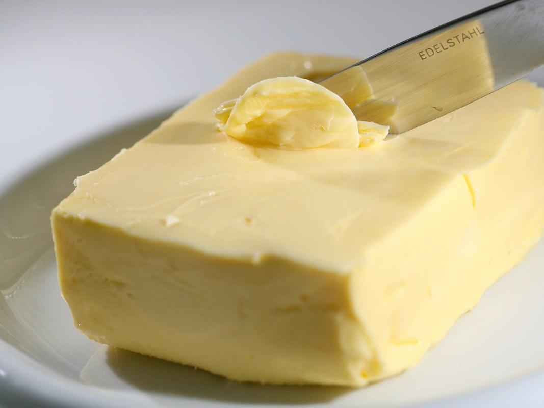 Mit einem Messer wird Butter abgestrichen.