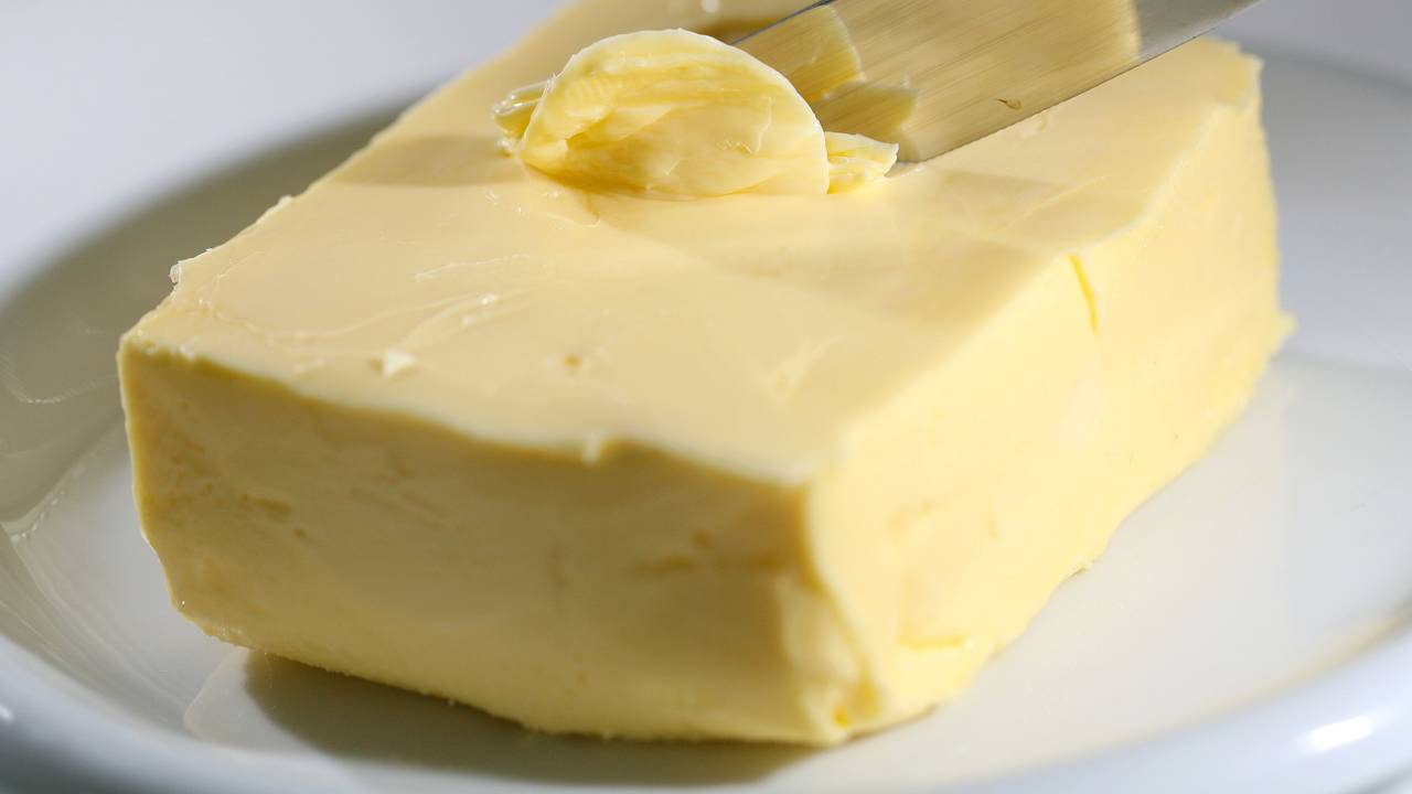 Mit einem Messer wird Butter abgestrichen.