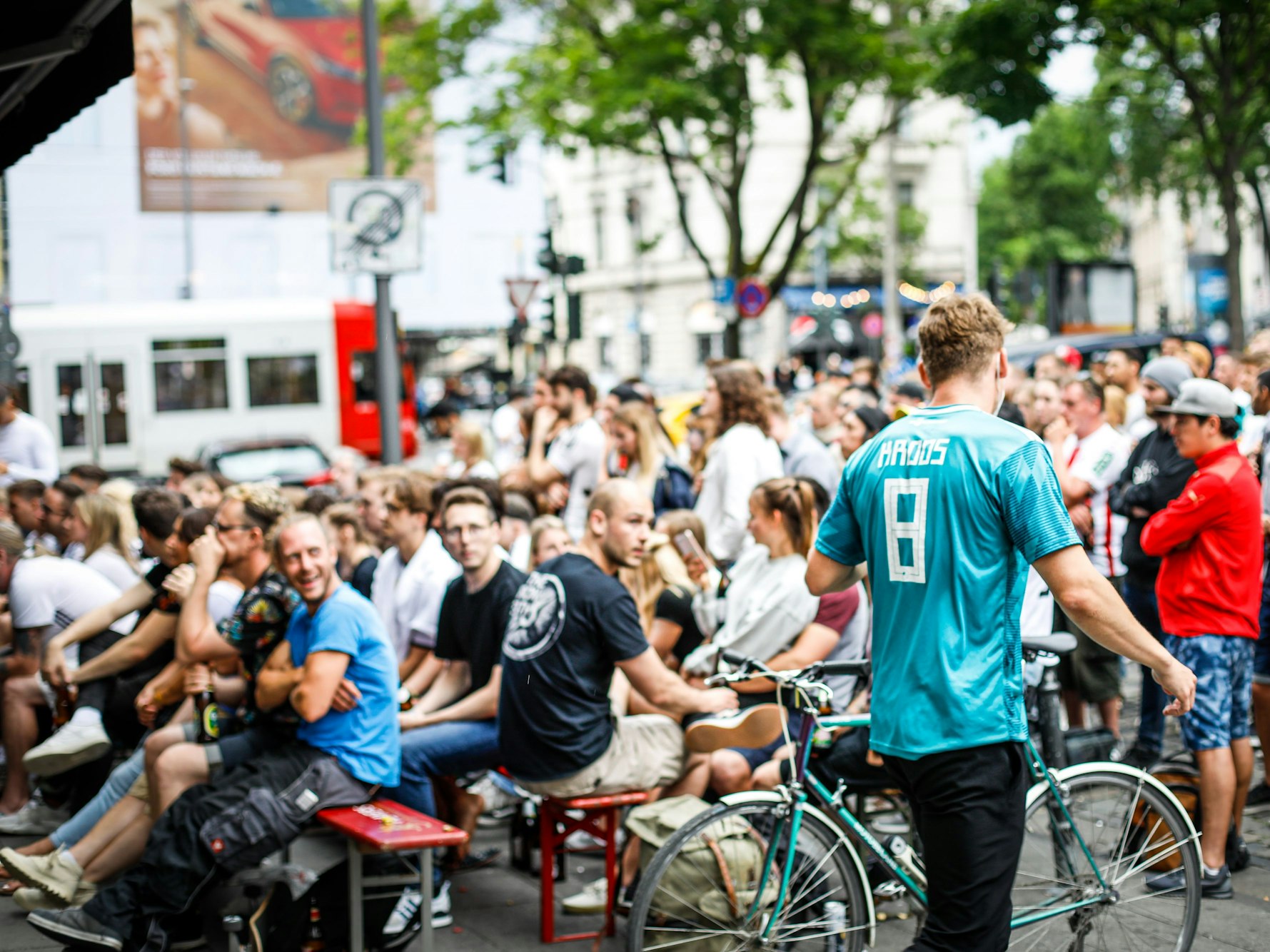 Fußballfans verfolgen am Zülpicher Platz in Köln gemeinsam ein Fußballspiel in Deutschland-Trikots.