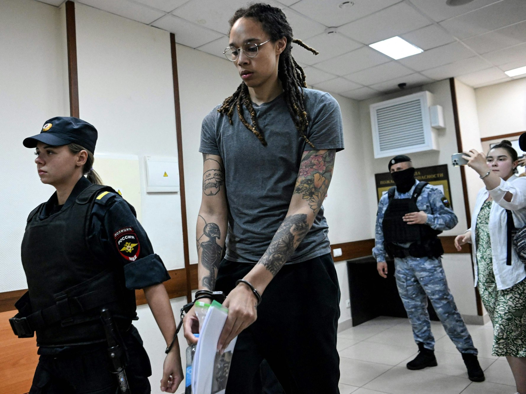 Brittney Griner wird mit Handschellen von einer russischen Beamtin aus dem Gericht abgeführt.