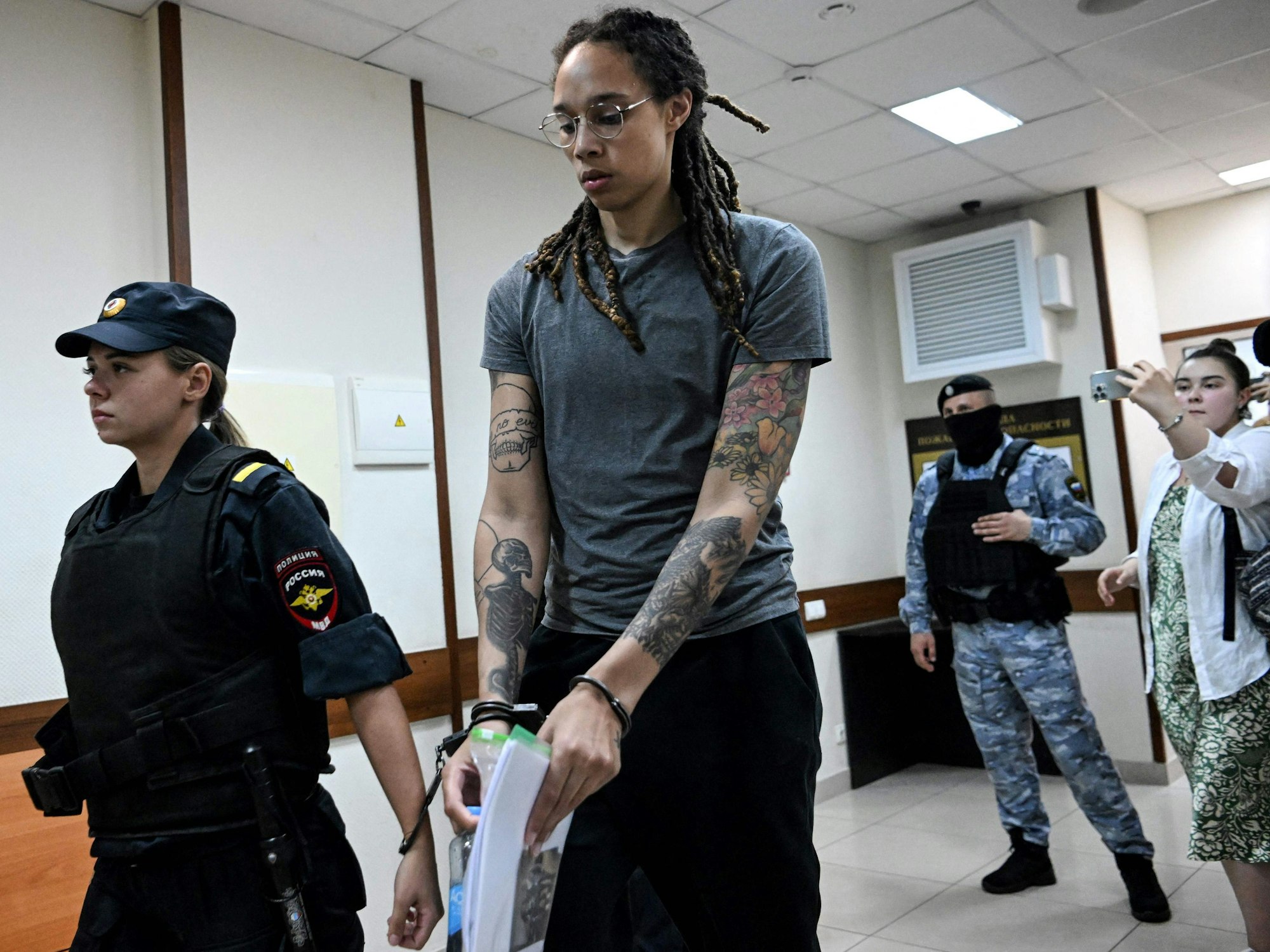 Brittney Griner wird mit Handschellen von einer russischen Beamtin aus dem Gericht abgeführt.