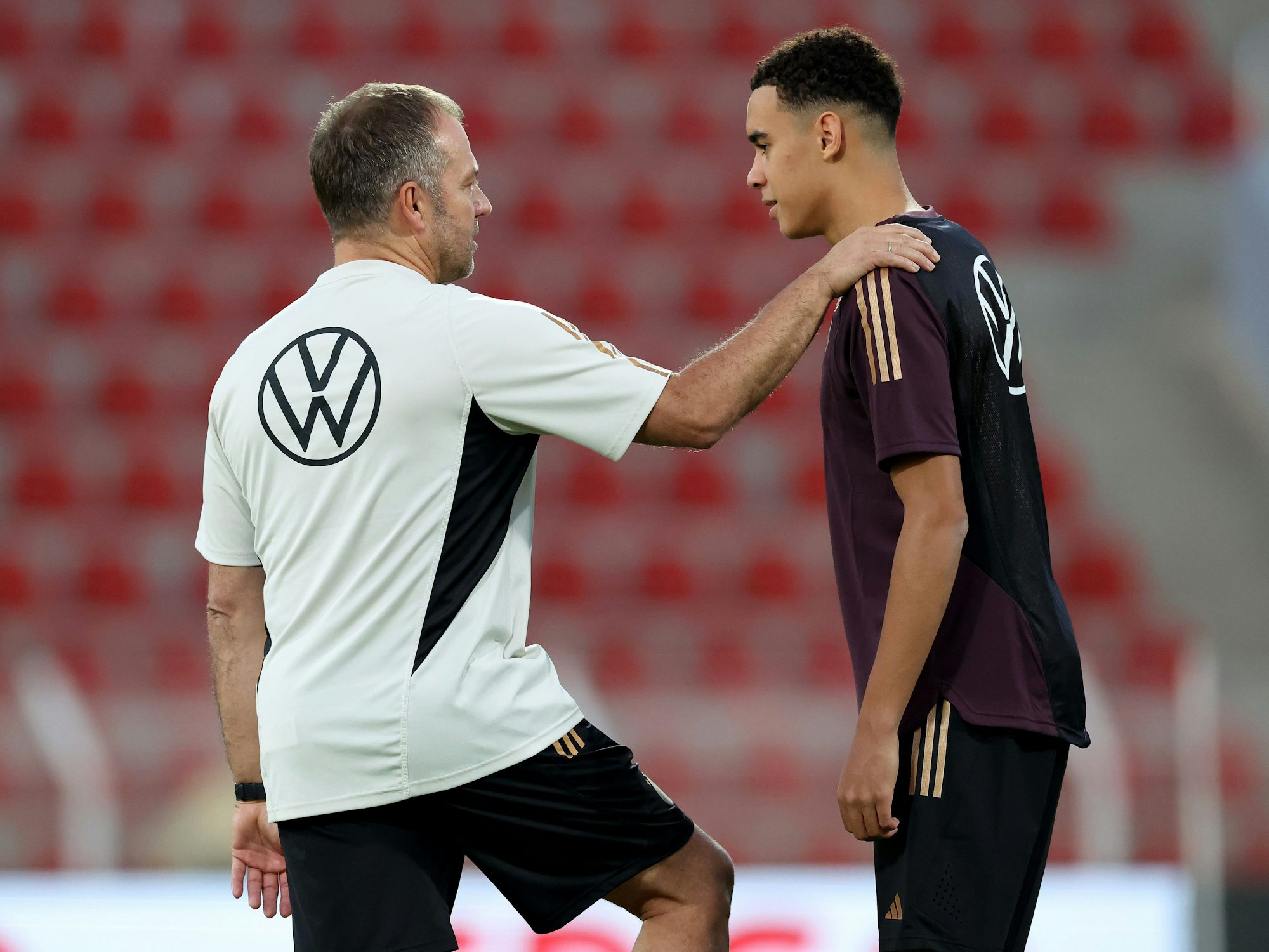 Hansi Flick spricht beim Training mit Jamal Musiala.