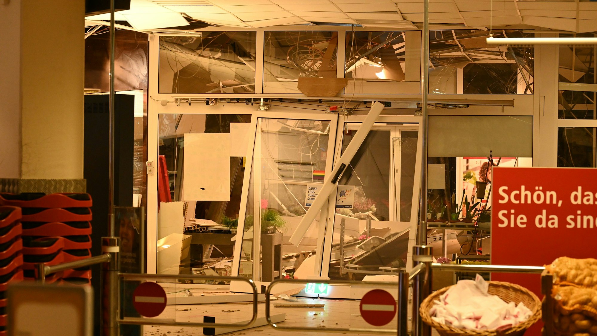 Ein Geldautomat in einem Supermarkt wurde gesprengt, auch Teile der Decke wurden beschädigt, Plastikverkleidungen und Kabel hängen herunter.