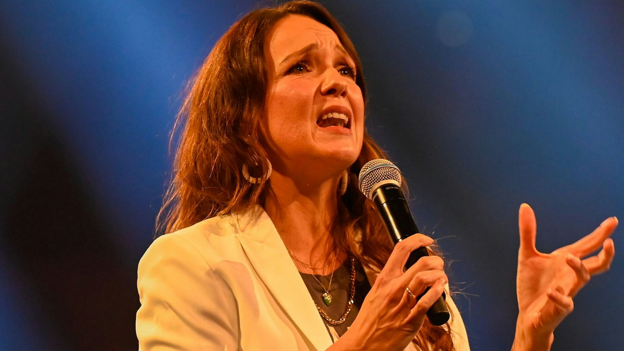 Carolin Kebekus steht auf der Bühne und spricht ins Mikrofon.