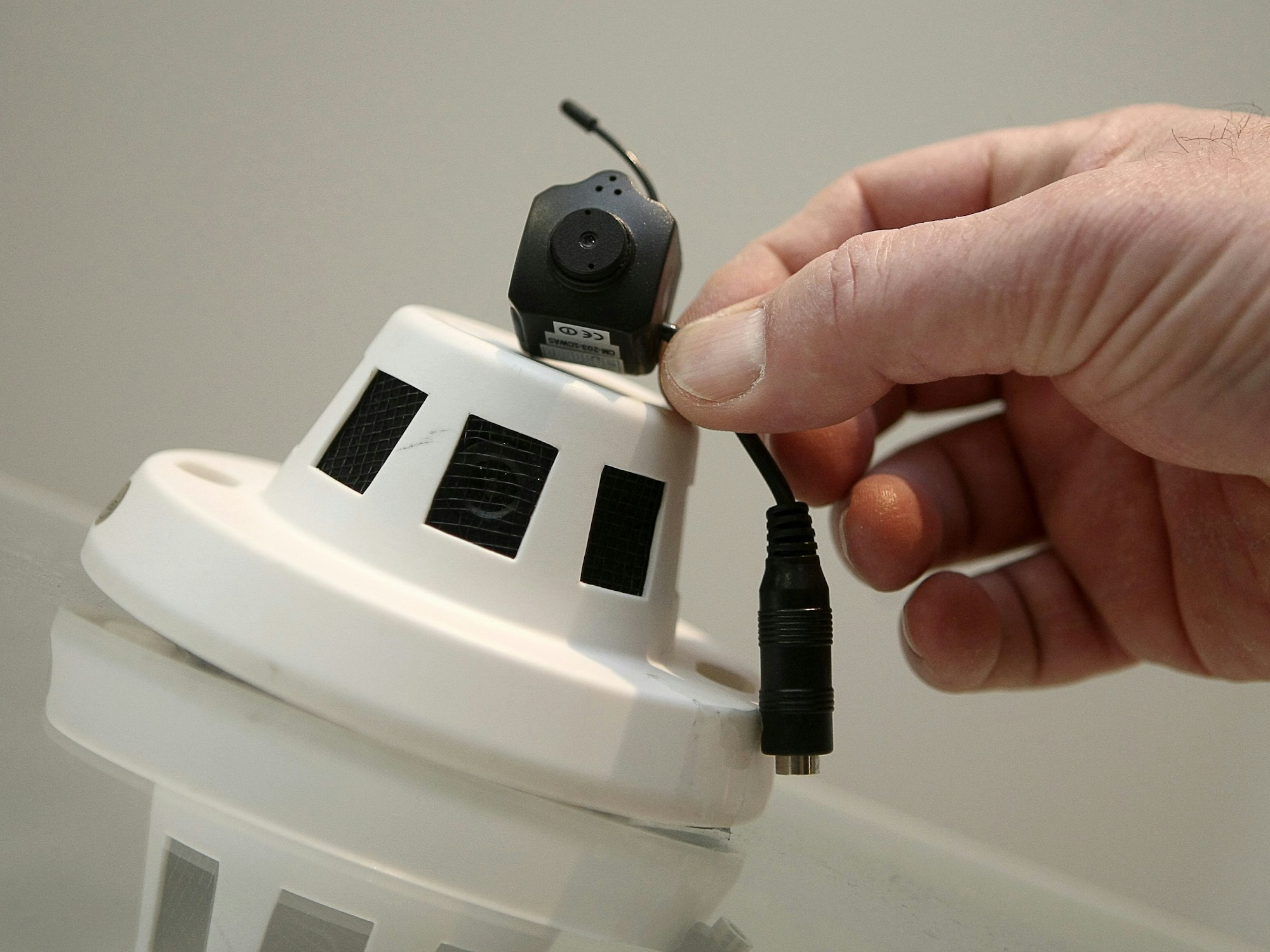 Im rheinland-pfälzischen Landeskriminalamt (LKA) in Mainz wird ein beschlagnahmter Rauchmelder gezeigt, der mit einer Mini-Kamera umgebaut worden ist.