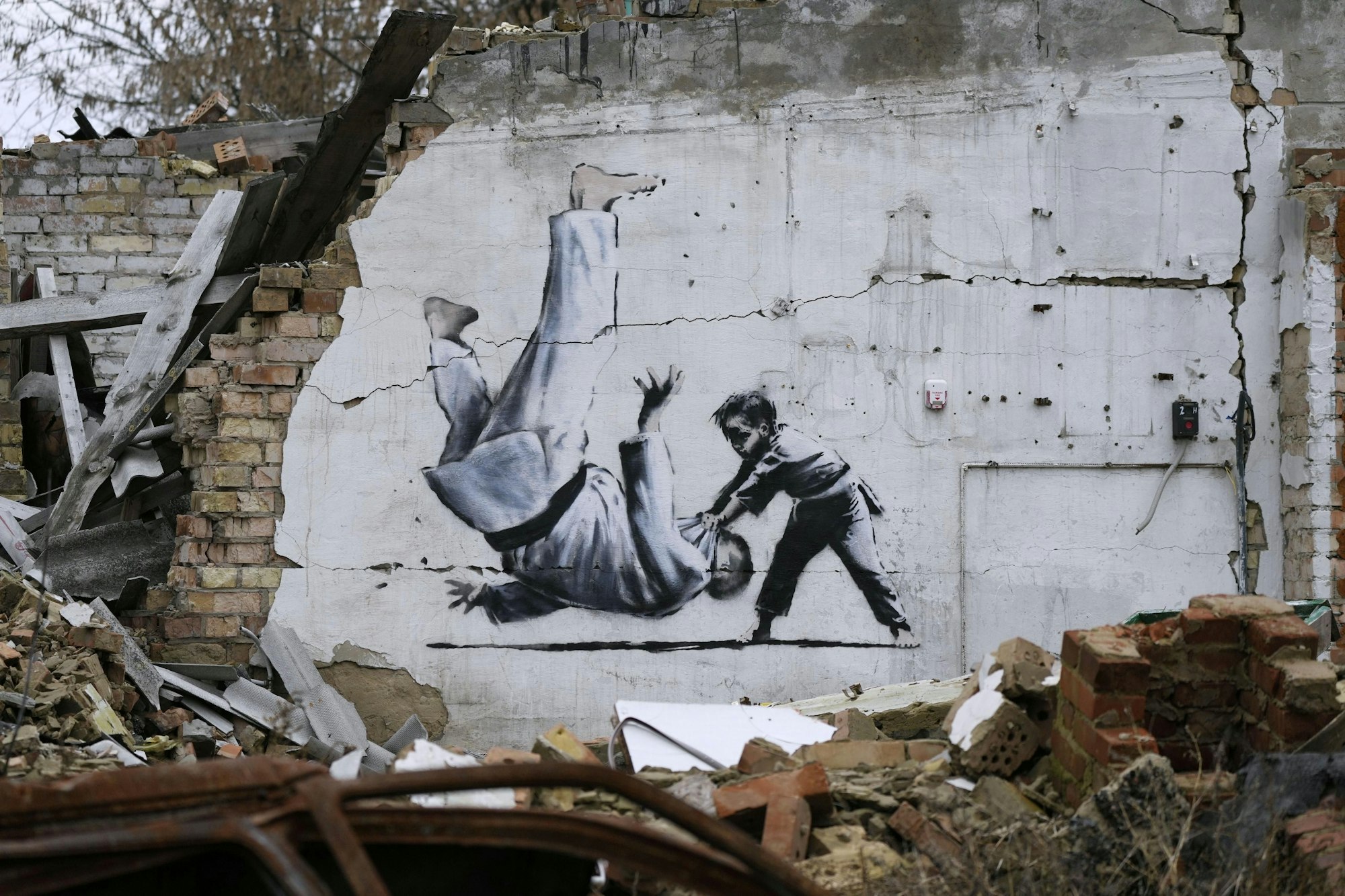 Ein Kunstwerk, das vermutlich von dem bekannten Graffitikünstler Banksy stammt, an einem beschädigten Gebäude in der Nähe von Kyjiw.