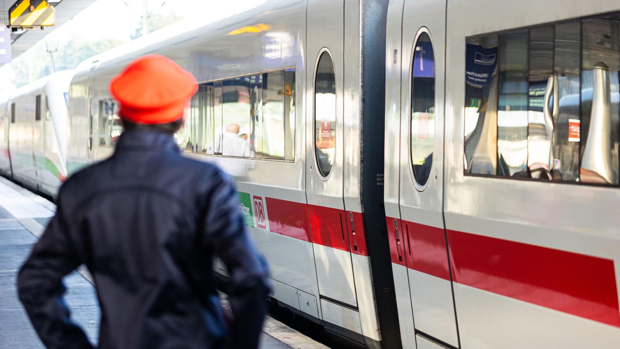 Ein Mitarbeiter der Deutschen Bahn (DB) steht neben einem ICE-Zug an einem Gleis im Hauptbahnhof Hannover.