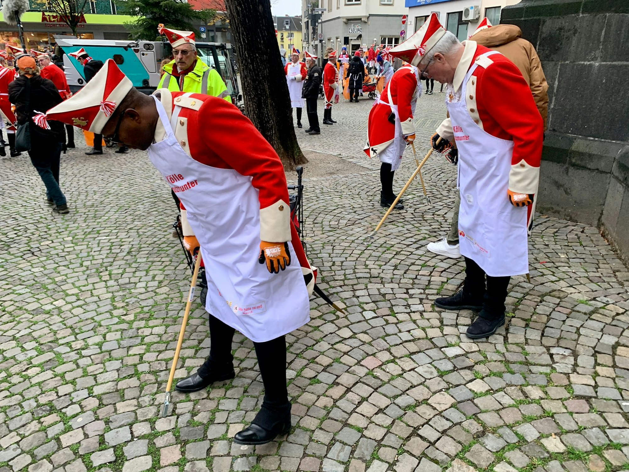 Mitglieder der Roten Funken sammeln Müll auf.