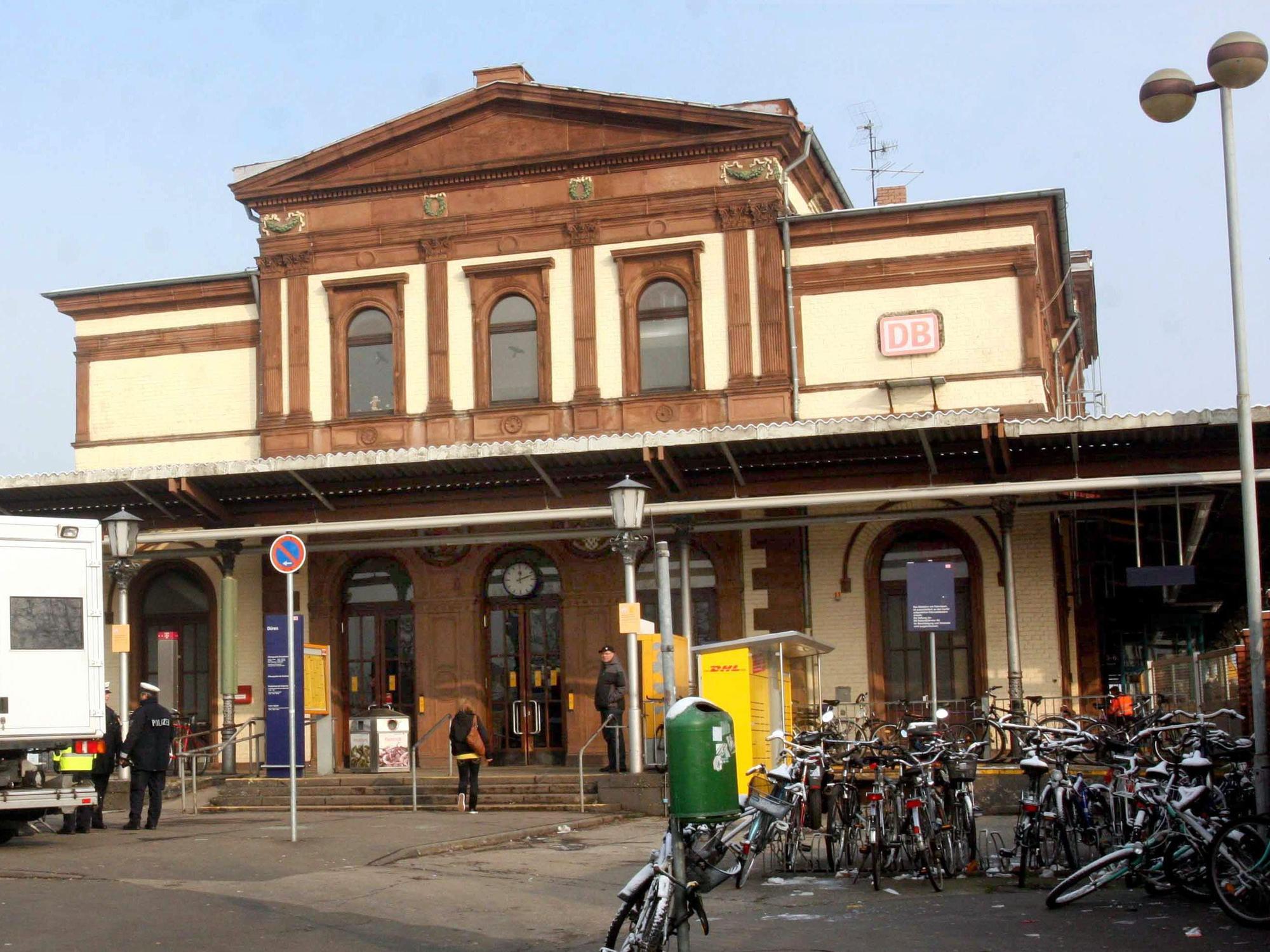 Polizeikräfte stehen vor dem Bahnhof in Düren.
