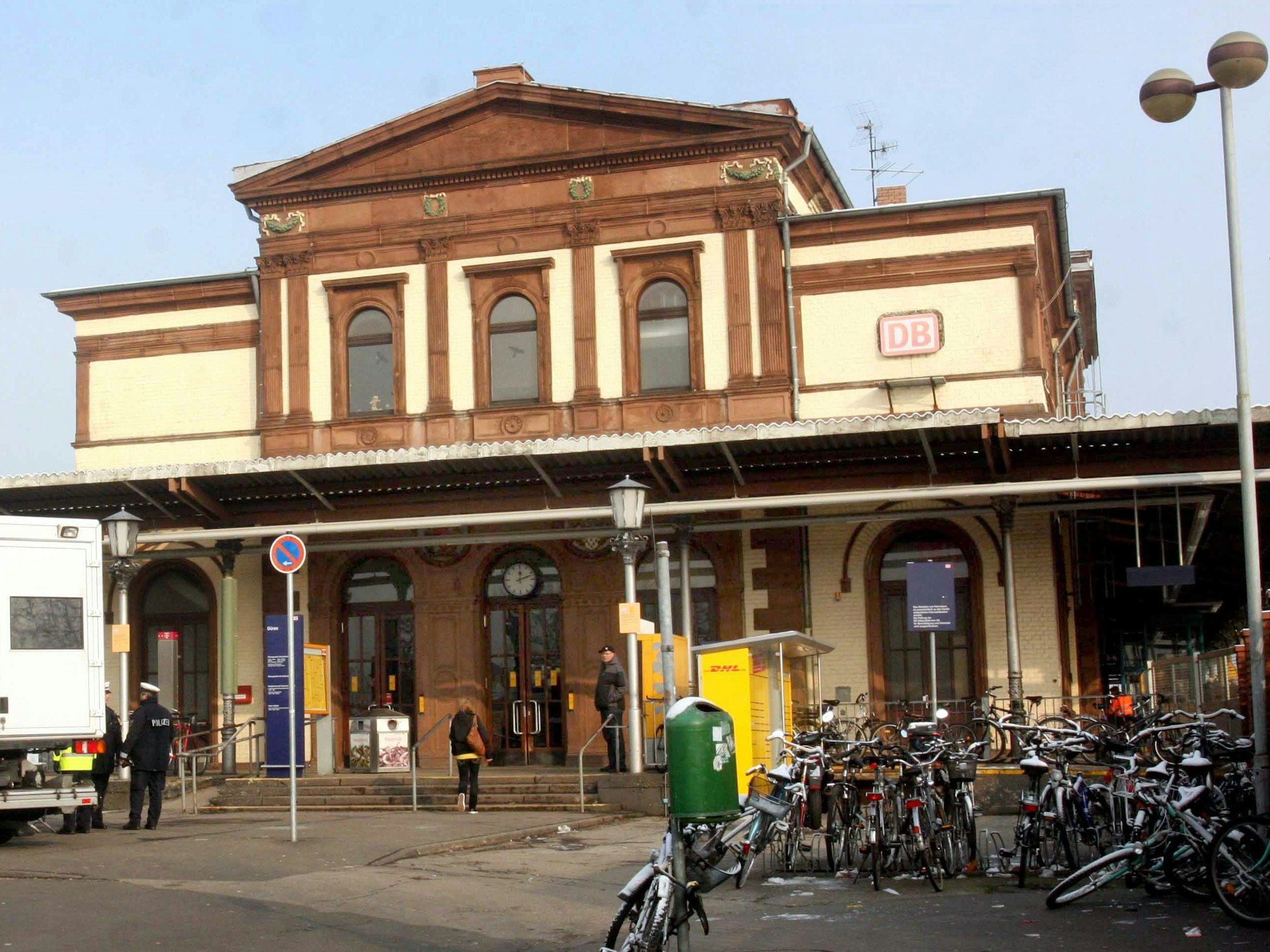 Polizeikräfte stehen vor dem Bahnhof in Düren.