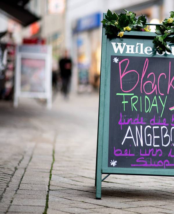 Ein Schild mit der Aufschrift „Black Friday Angebote“ steht vor einem Geschäft.
