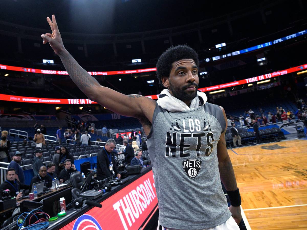 Kyrie Irving zeigt ein Peace-Zeichen mit seiner Hand in Richtung Fans.