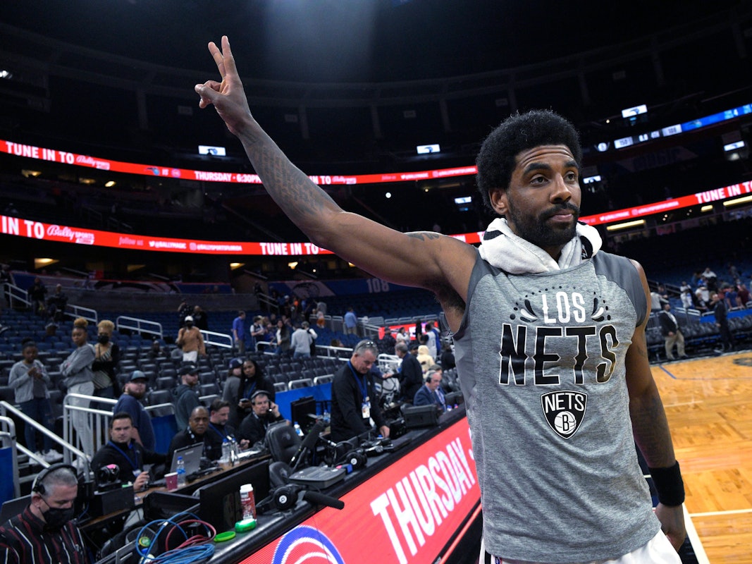 Kyrie Irving zeigt ein Peace-Zeichen mit seiner Hand in Richtung Fans.