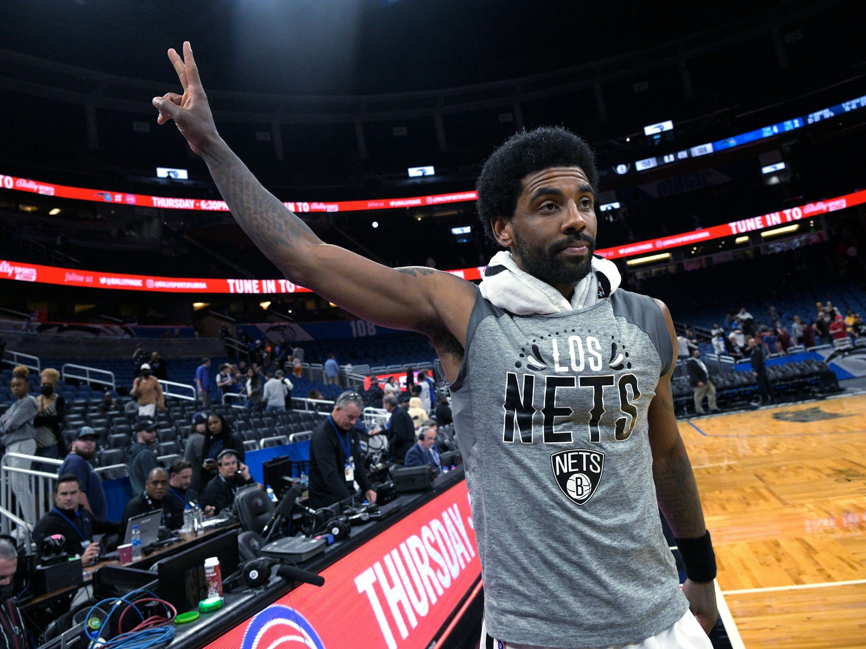 Kyrie Irving zeigt ein Peace-Zeichen mit seiner Hand in Richtung Fans.