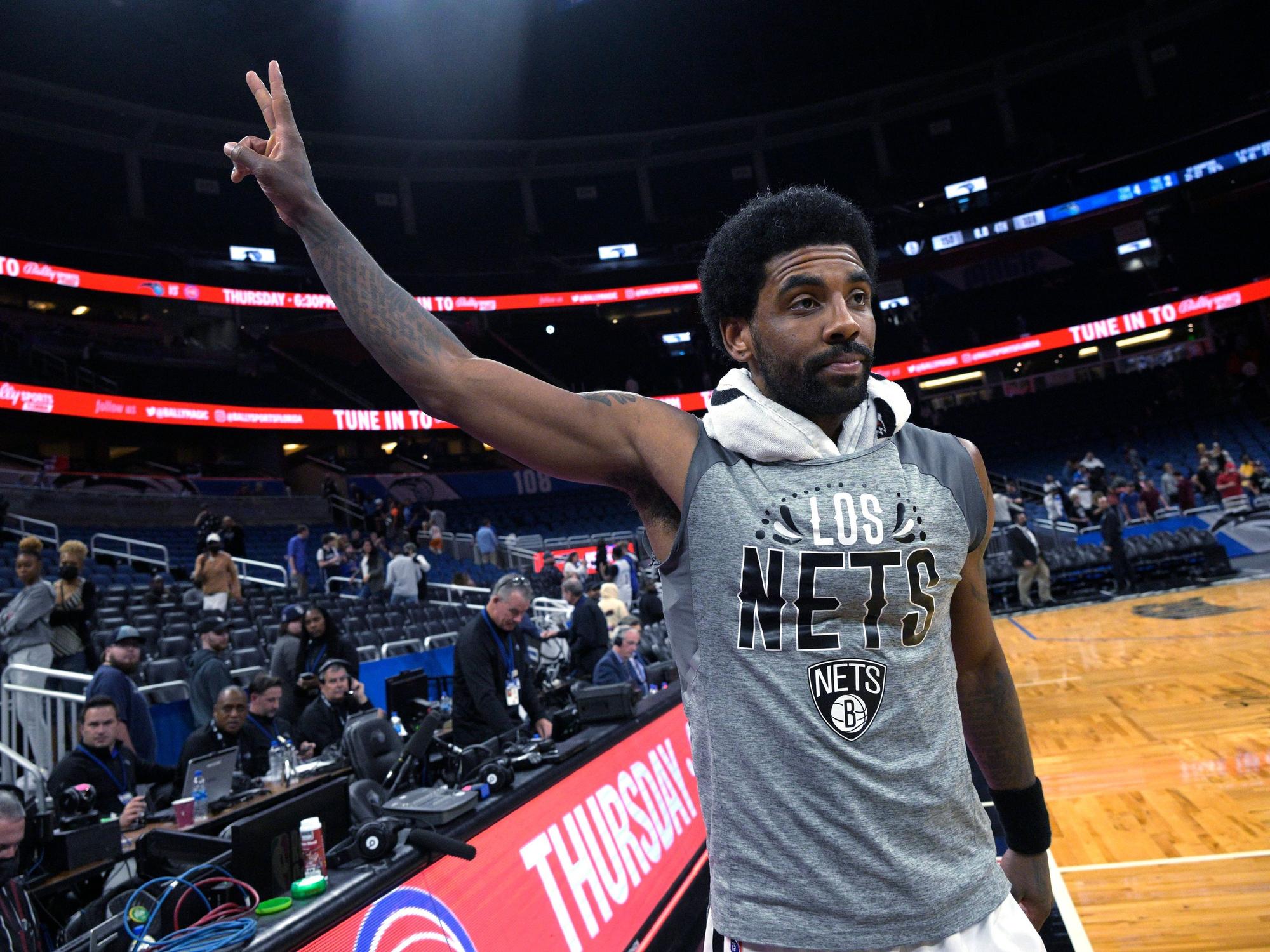 Kyrie Irving zeigt ein Peace-Zeichen mit seiner Hand in Richtung Fans.