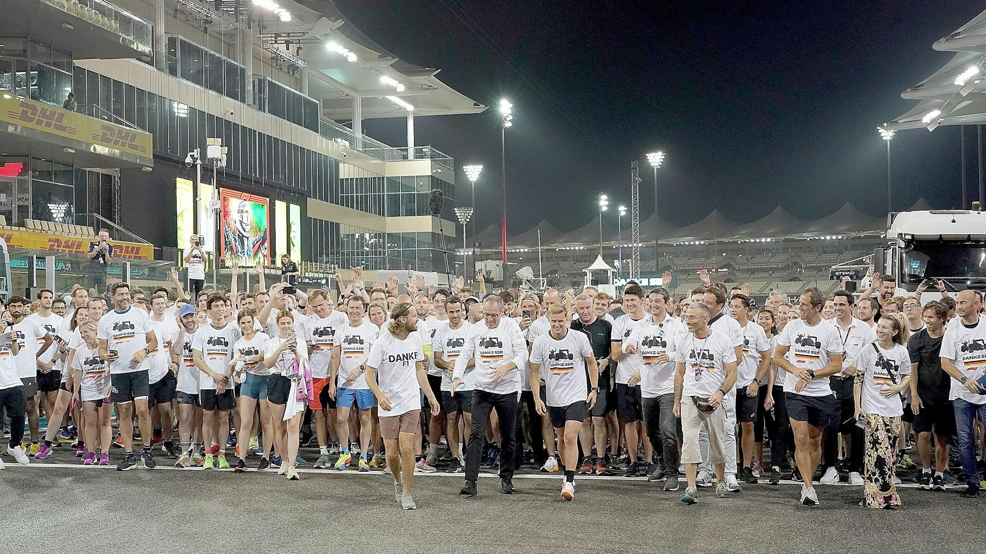 Sebastian Vettel sowie zahlreiche Kollegen und Freunde an der Ziellinie auf der Strecke in Abu Dhabi.