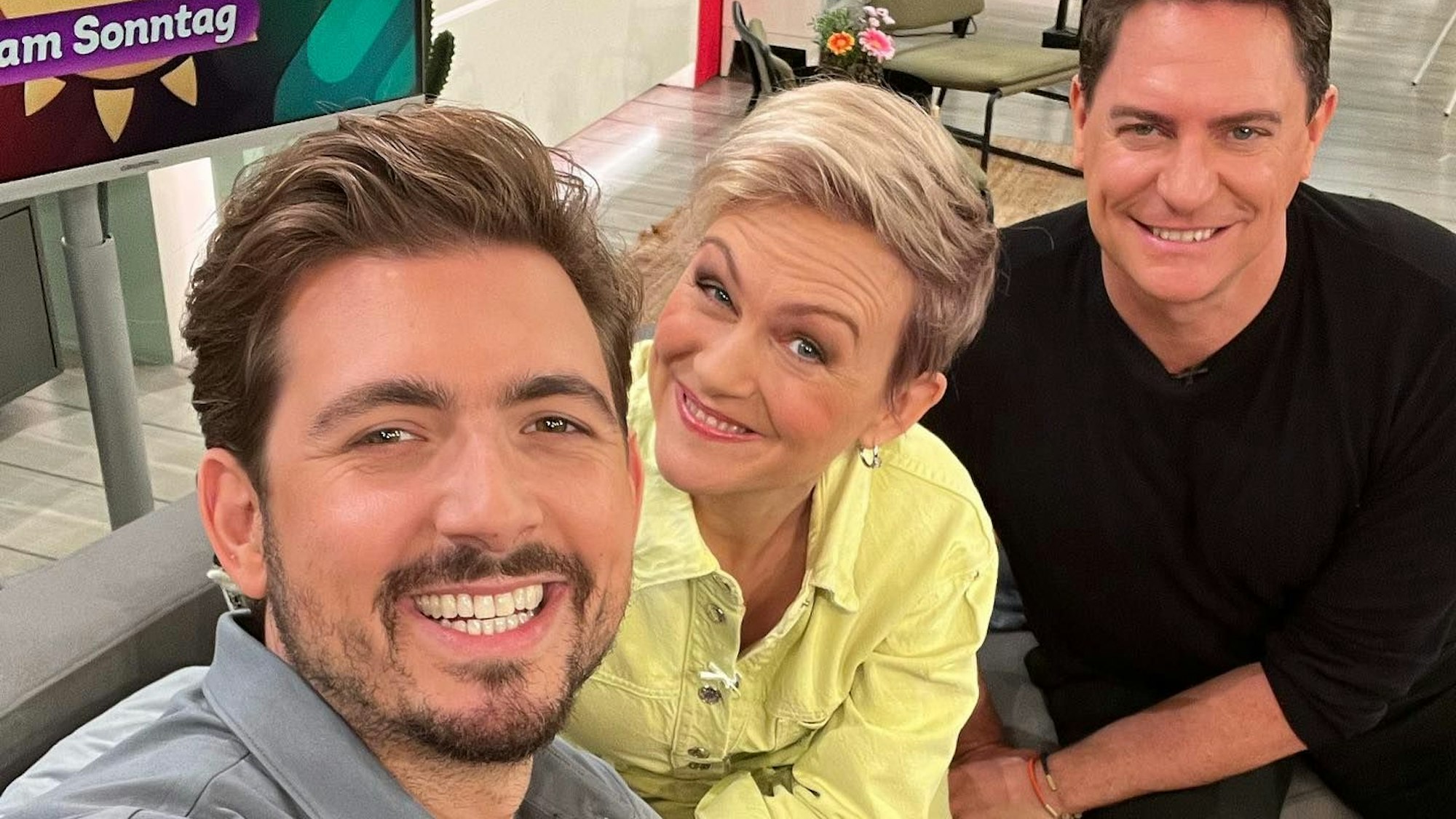 Christan Wackert, Karen Heinrichs und Benjamin Bieneck lächeln für ein Selfie in die Kamera.