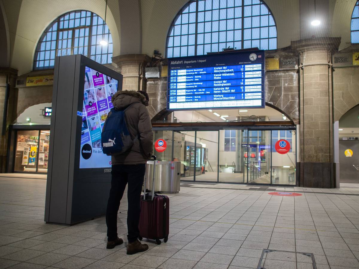 Ein Mann steht im Hagener Hauptbahnhof vor der Anzeigetafel.