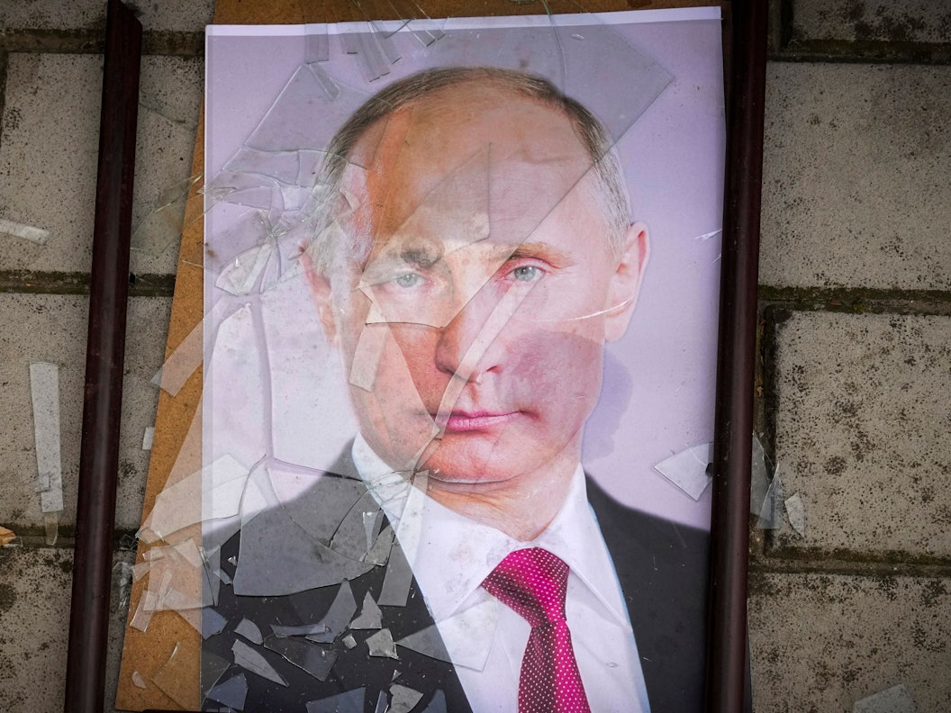 Ein Foto Wladimir Putins liegt in einem zerbrochenen Bilderrahmen.
