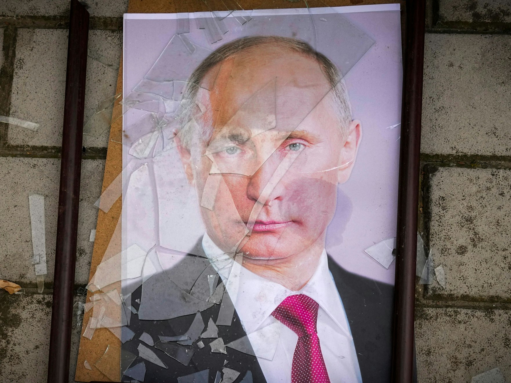 Ein Foto Wladimir Putins liegt in einem zerbrochenen Bilderrahmen.
