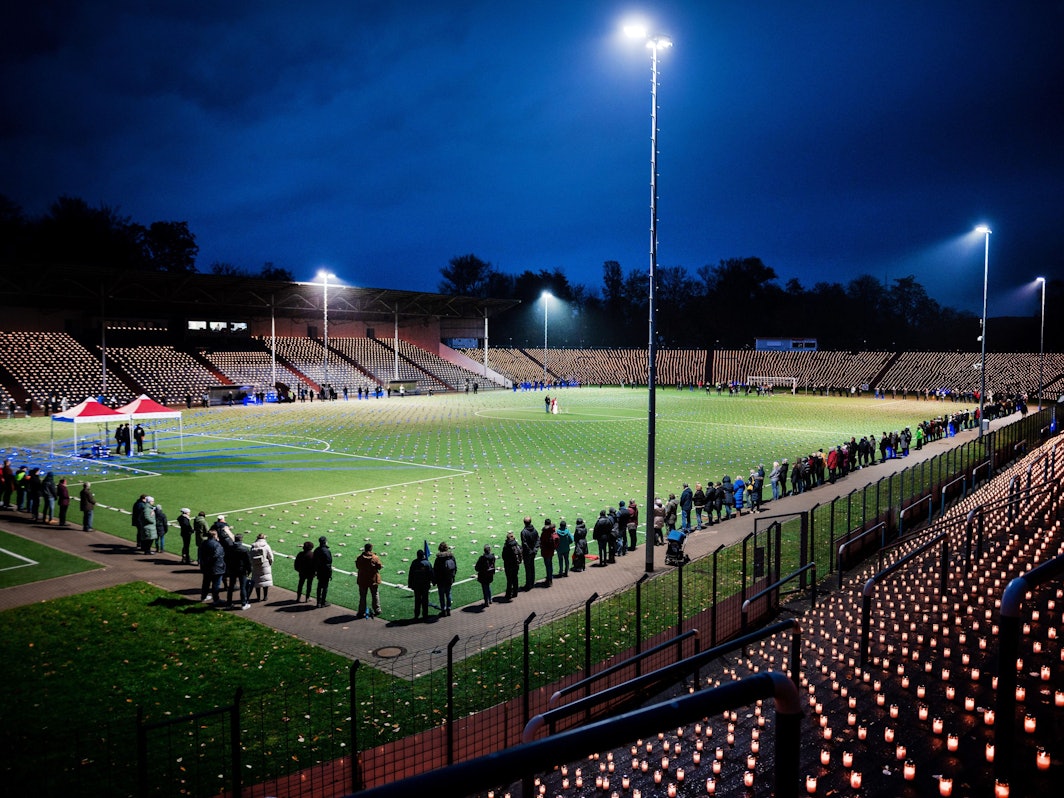 Hell erleuchtetes Stadion mit Flutlicht und 20.000 Kerzen. Die Aktion ist ein Protest gegen die Fußball-WM in Katar.
