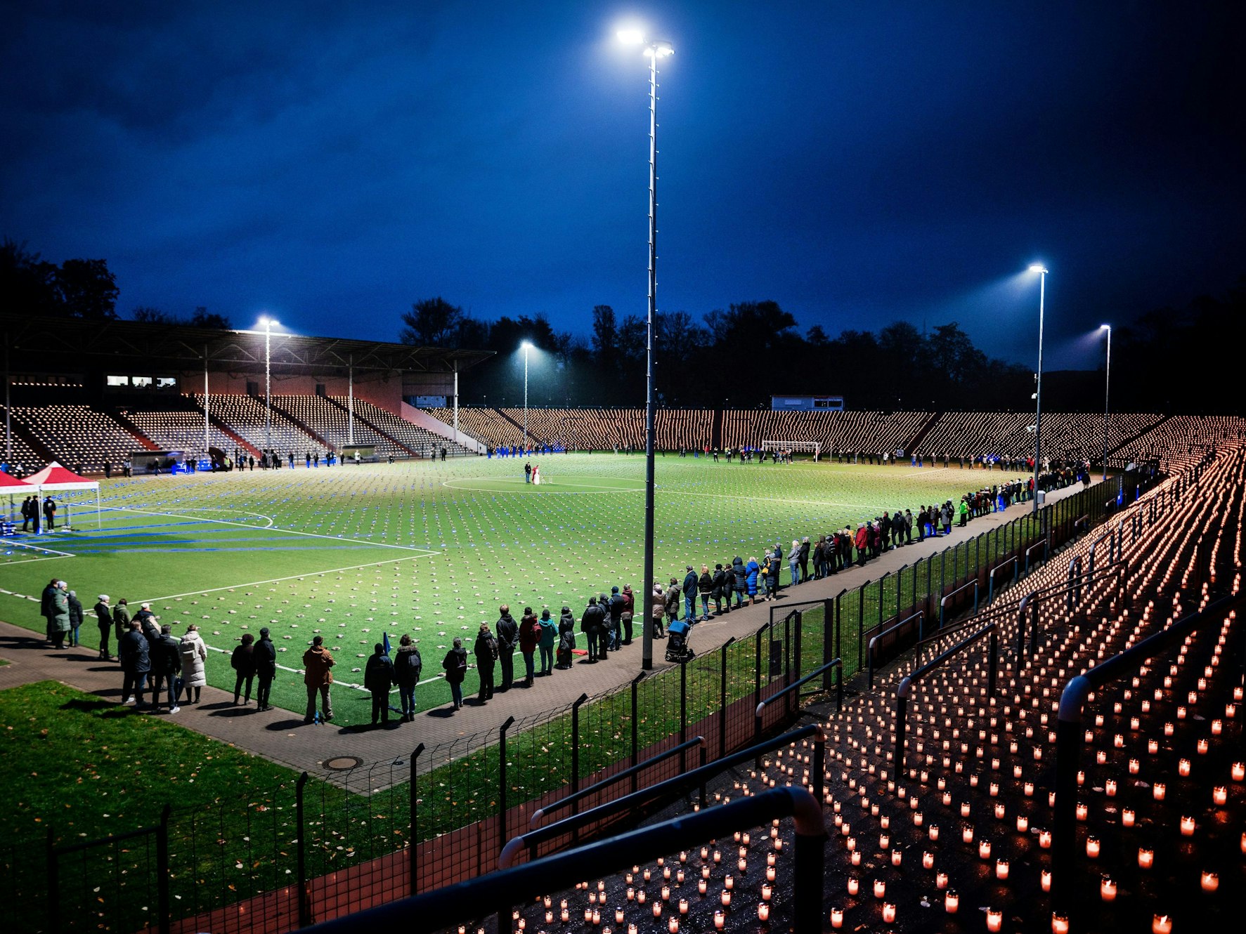 Hell erleuchtetes Stadion mit Flutlicht und 20.000 Kerzen. Die Aktion ist ein Protest gegen die Fußball-WM in Katar.