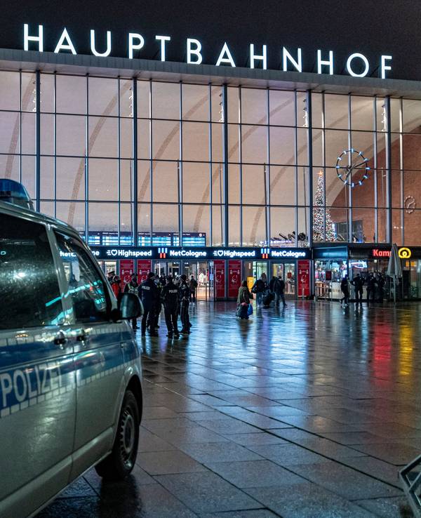 Ein Polizeiwagen steht im Dunkeln vor dem Kölner Hauptbahnhof.