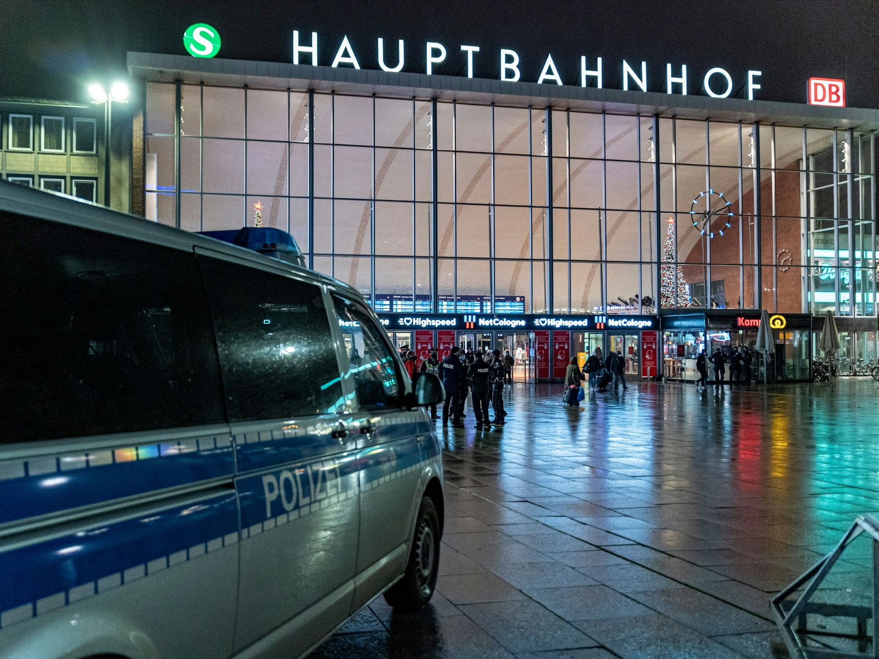 Ein Polizeiwagen steht im Dunkeln vor dem Kölner Hauptbahnhof.