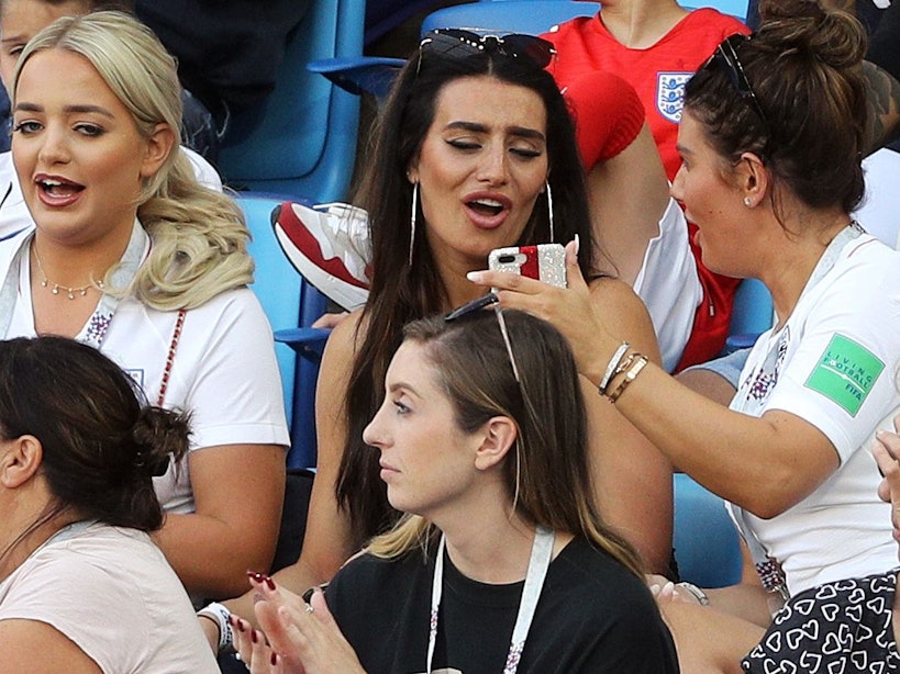 Fußball, WM, Vorrunde, Gruppe G, 3. Spieltag: England - Belgien im Kaliningrad Stadion: Obere Reihe (l-r), Megan Davison, Freundin des englischen Torhüters Pickford, Annie Kilner, Freundin des englischen Nationalspielers Walker und Rebekah Vardy, Frau des englischen Nationalspielers Vardy sitzen vor Spielbeginn auf der Tribüne.