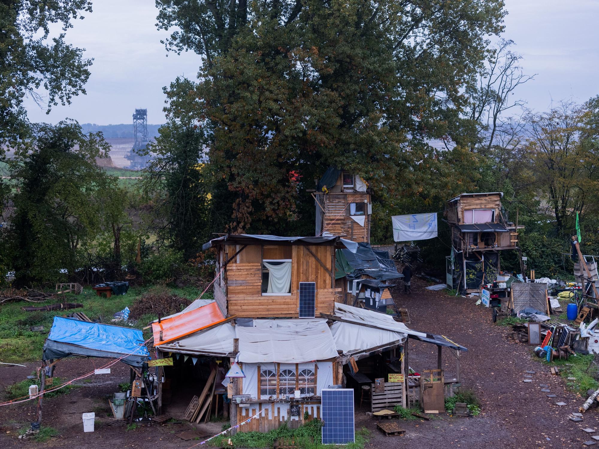 Holzhäuser stehen im Protestcamp von Umweltaktivisten in Lützerath.