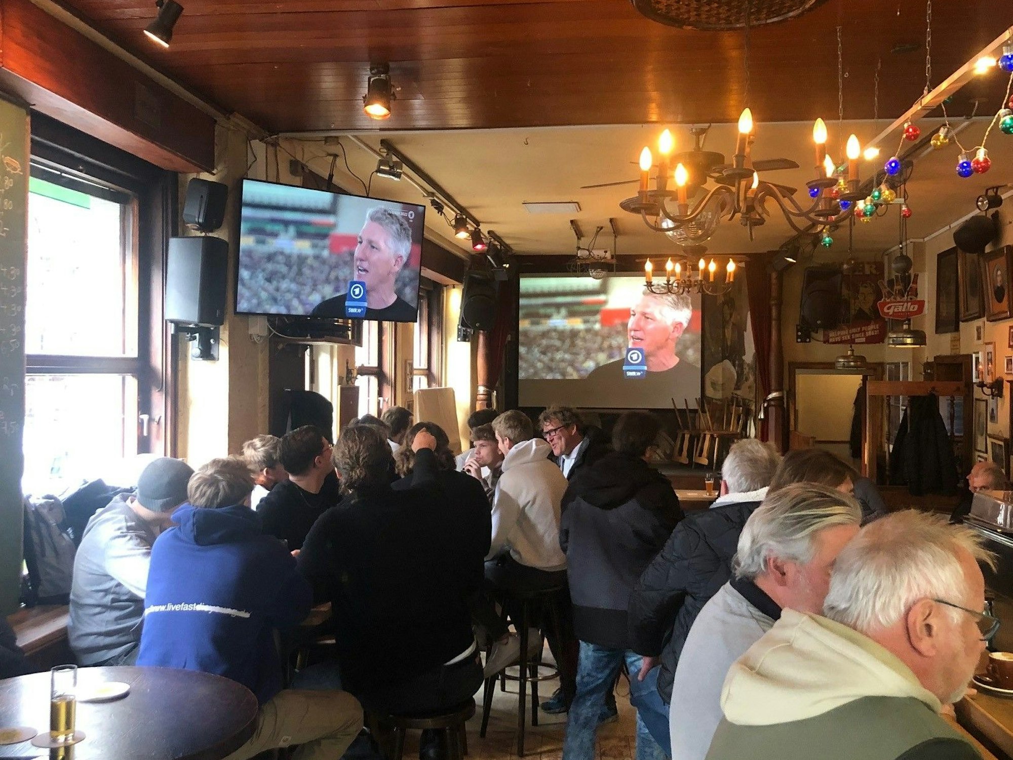 Gäste in der „Ubierschänke“ schauen das Fußballspiel.