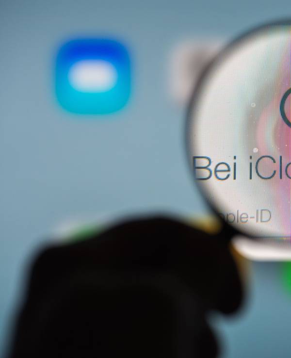 Eine Hand hält am 13.01.2014 in Straubing (Bayern) ein Vergrößerungsglas vor die Internetseite des Online-Speicherdienstes iCloud von Apple.