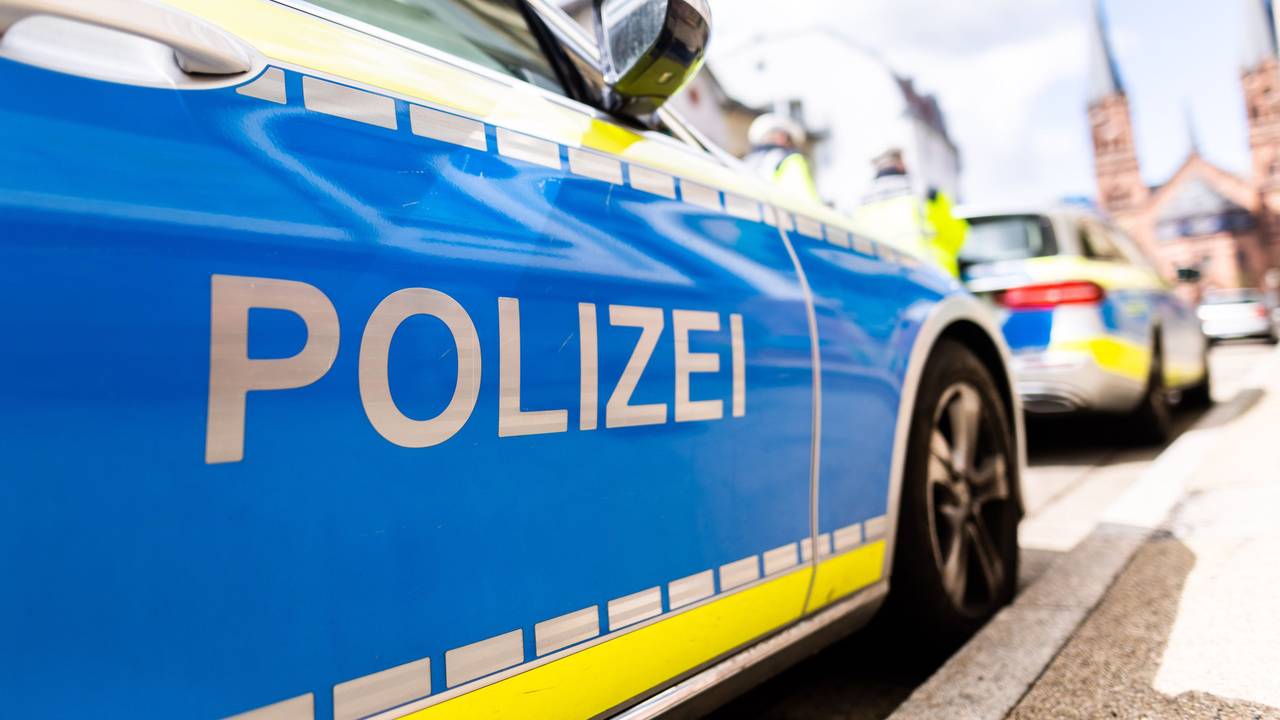 Zwei Einsatzfahrzeuge der Polizei stehen in Freiburg am Straßenrand.