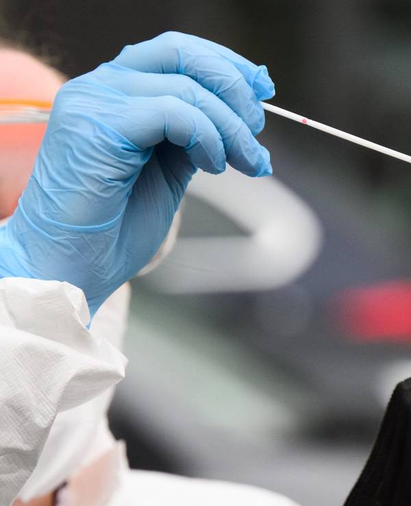 Eine Hausärztin nimmt einen Abstrich von einer Patientin für einen PCR-Test auf das Corona-Virus vor einer Arztpraxis in der Region Hannover.