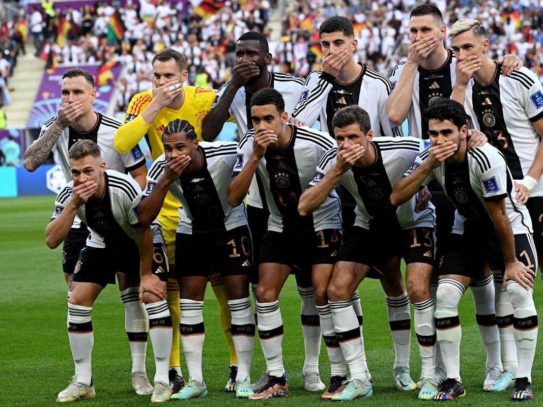 Die deutschen Nationalspieler halten sich beim Mannschaftsfoto den Mund zu.