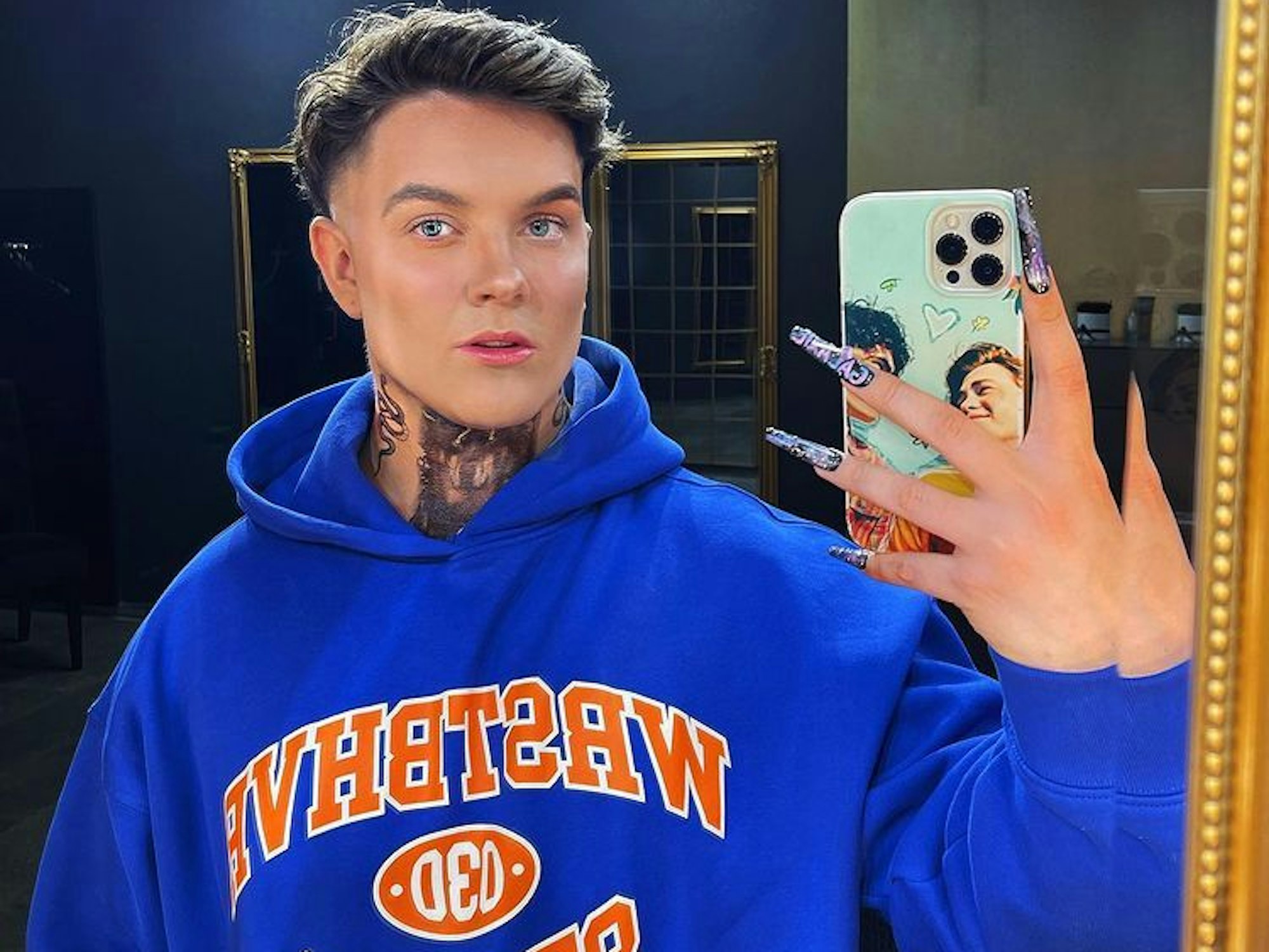 Tim Maximilian Kampmann alias Twenty4Tim steht im November 2022 vor dem Spiegel und blickt in die Kamera.